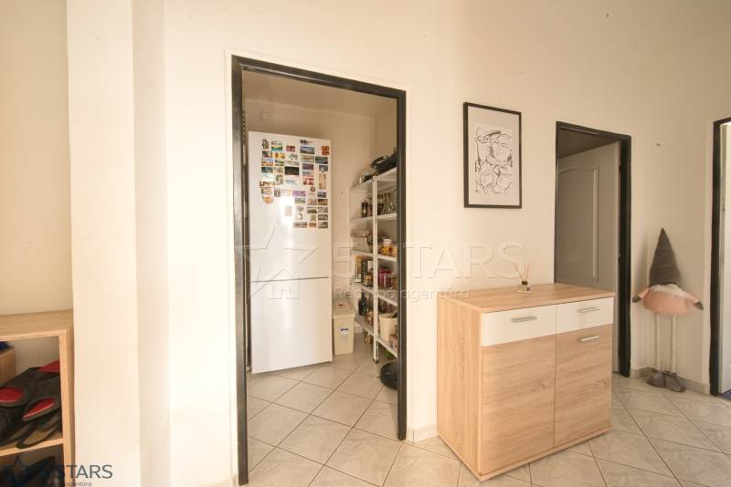 A hallway with a wardrobe and a refrigerator in a 3-room apartment with decorative elements.