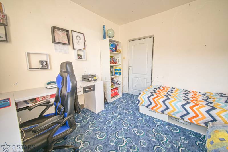 Children's room with a bed, desk, and shelf in a 3-room apartment.