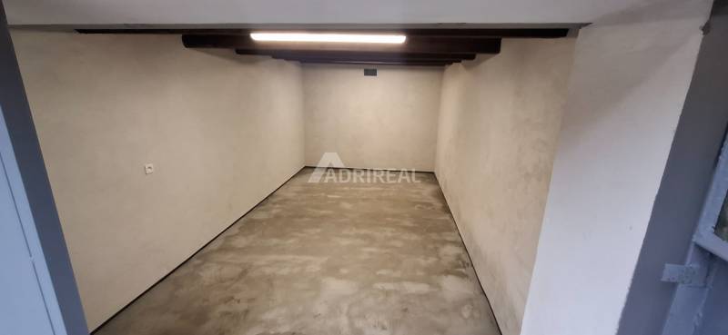 Empty garage with concrete floor and lighting.