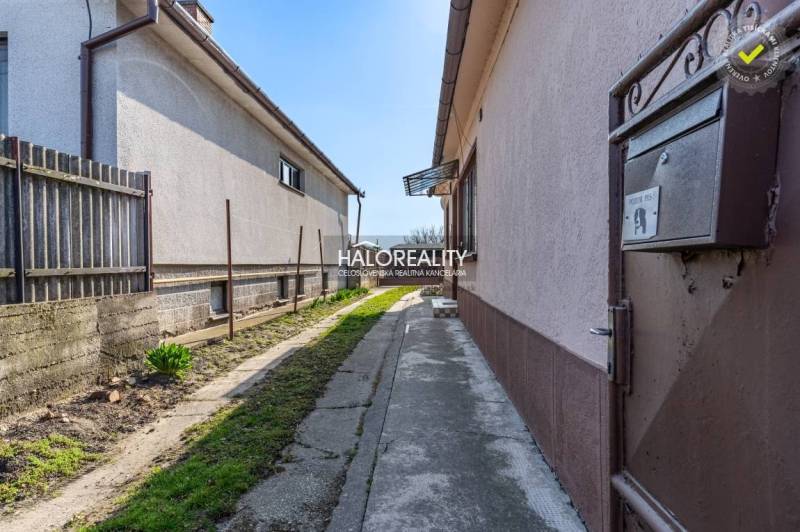 A narrow path between the buildings of a family house in Horná Potôň with a small garden.