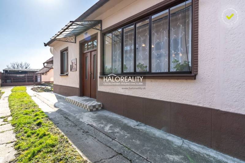 A family house in Horná Potôň with a glass veranda and a front garden.