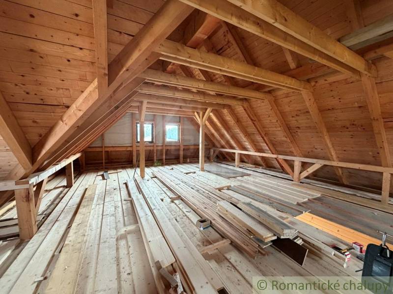 The attic of a family house with a wooden structure and a lot of building materials.