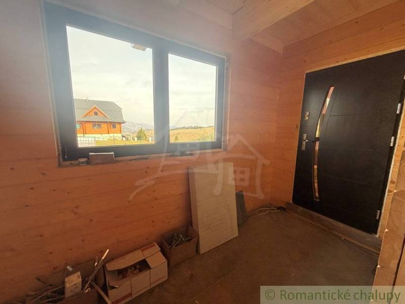 Interior of a family house with wooden decor, large window, and doors.