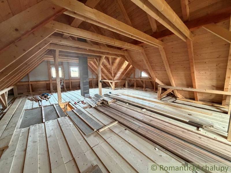 An attic of a family house with wooden decorative elements and beams.