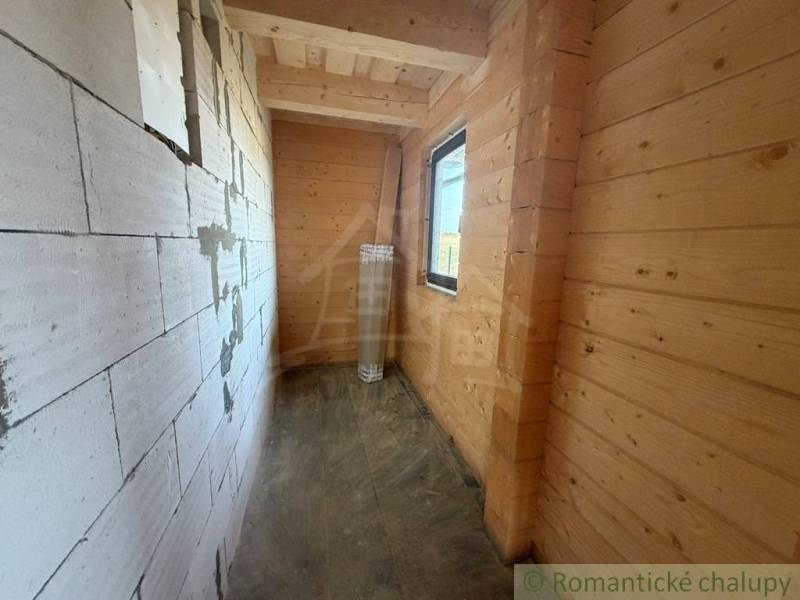 A narrow space with wooden paneling and a brick wall in a family house.