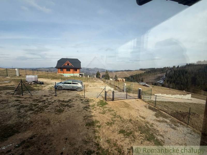A view of a family house in Lom nad Rimavicou with a view of the hills and a car.
