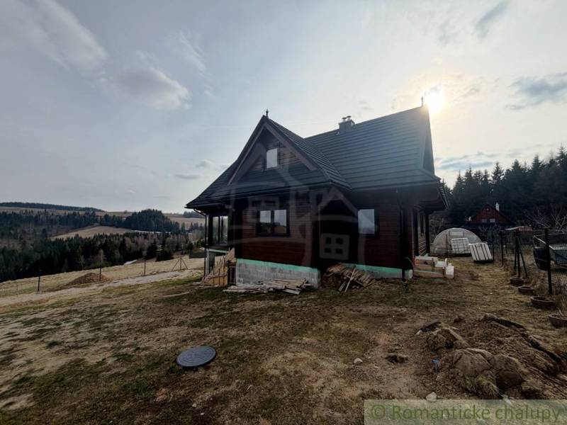 A family house in Lom nad Rimavicou, surrounded by natural scenery and hilly terrain.