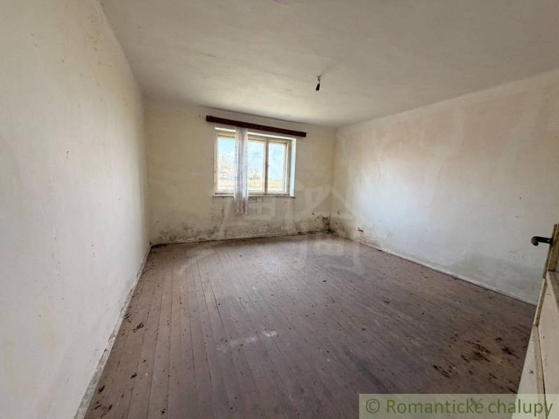 A room in a family house with a wooden decor floor and a large window.
