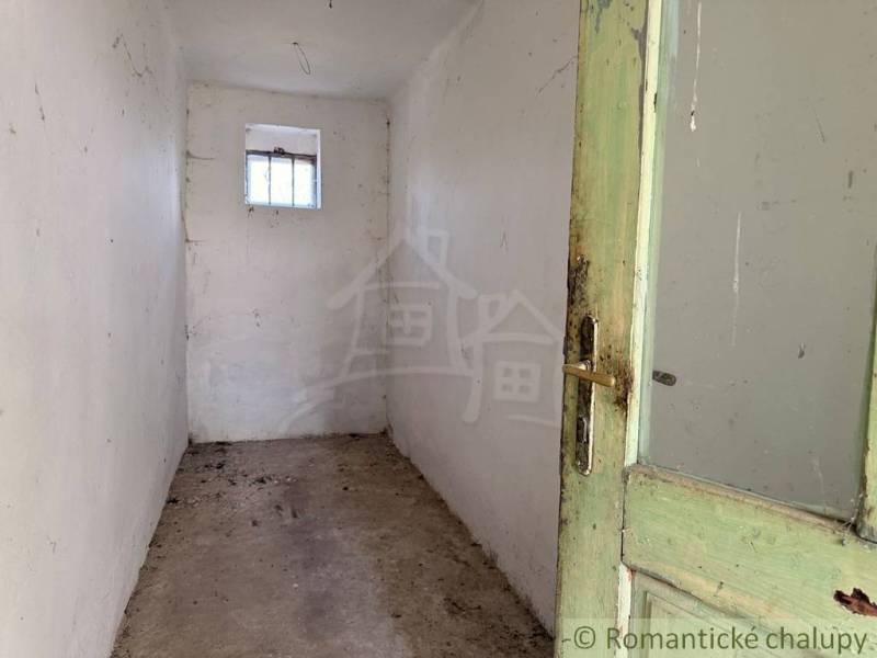 A narrow space with wooden doors and a small window in a family house.