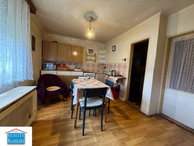 A kitchen in a family house with a wooden decor floor, a dining table, and furniture.