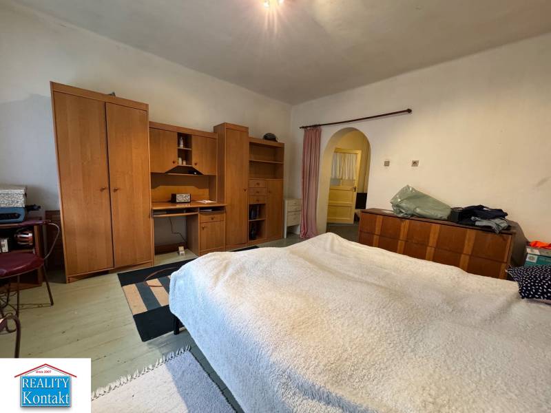 A bedroom in a family house with wooden furniture and a floor with a wood decor.