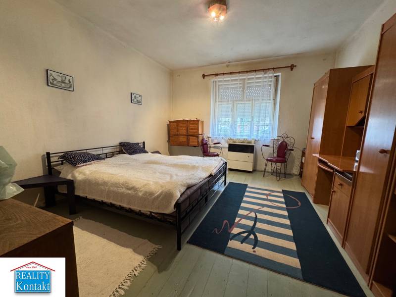 A bedroom in a family house with a comfortable bed and simple furniture.