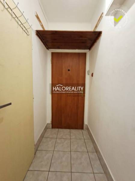 Entrance to a studio apartment with tiles and wooden doors.