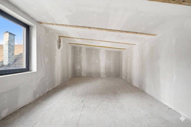 Attic space in a family house with a view of the roof through the window.