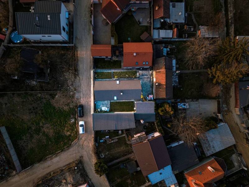 A view from above of family houses in Poprad with visible roofs and a road.