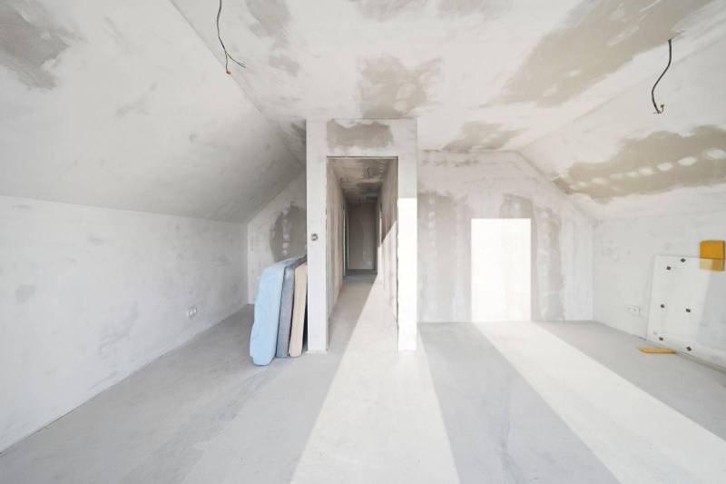 Interior of a family house with unfinished walls, illuminated by natural light.