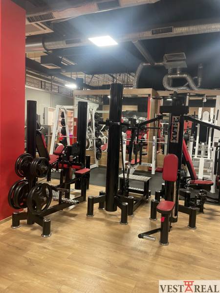 Commercial premises with exercise machines and a wooden decor floor.