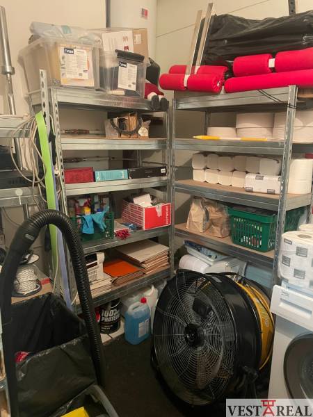 Warehouse in commercial premises with shelves full of various supplies.