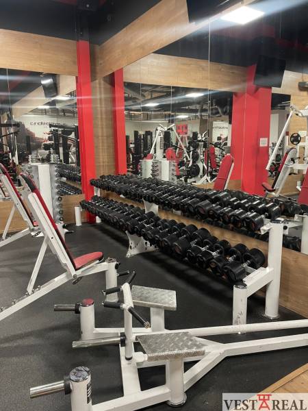 Fitness center with dumbbells and exercise equipment, commercial premises.