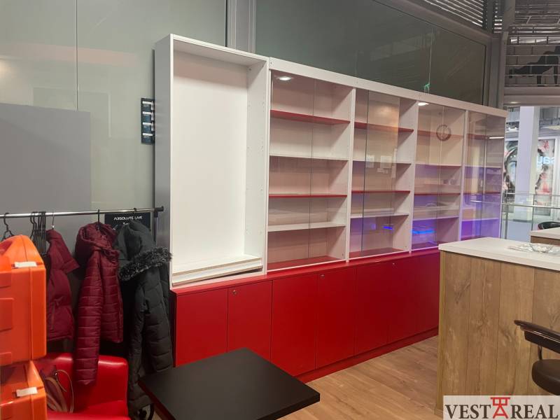 Commercial space with glass showcases and a hanger, floor with wood decor.