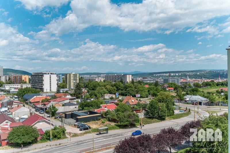 View from Pražská Street in Košice, Západ district, towards greenery and buildings.