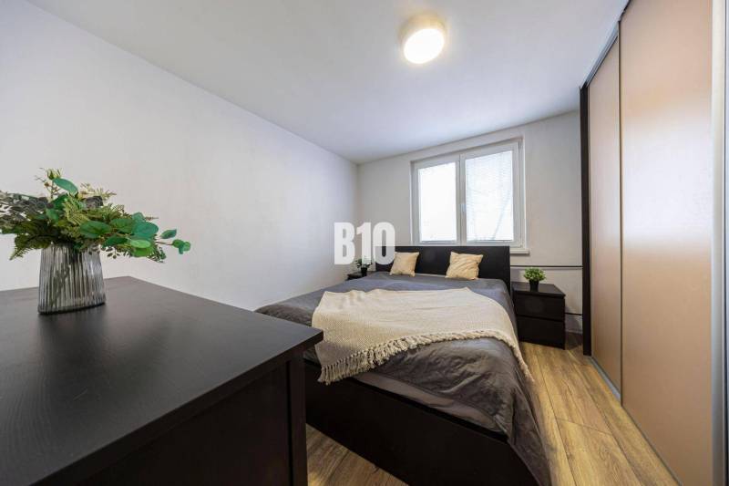 Bedroom with a double bed, wardrobes, chest of drawers, wooden decor flooring, 3-room apartment.