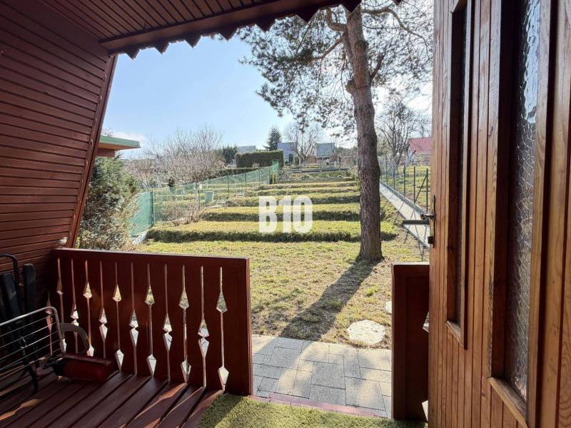 The veranda of the cottage in Martin with a view of the landscaped garden with a lawn.