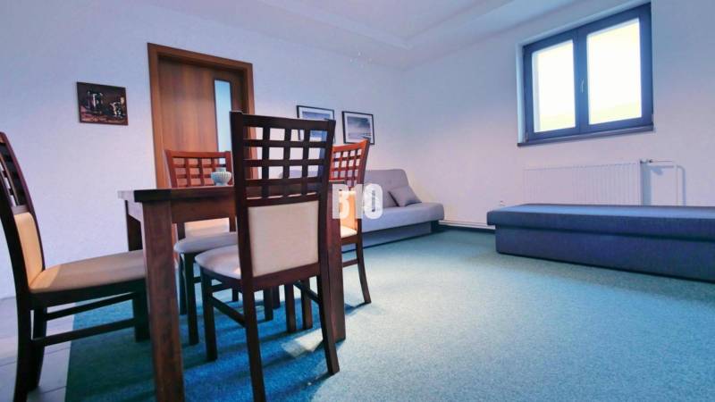 Dining room in a 3-room apartment with wooden furniture and blue flooring.