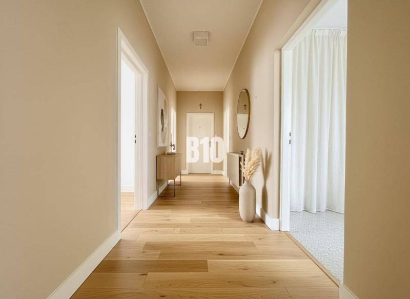 A hallway in a family house with a wooden decor floor and simple furnishings.