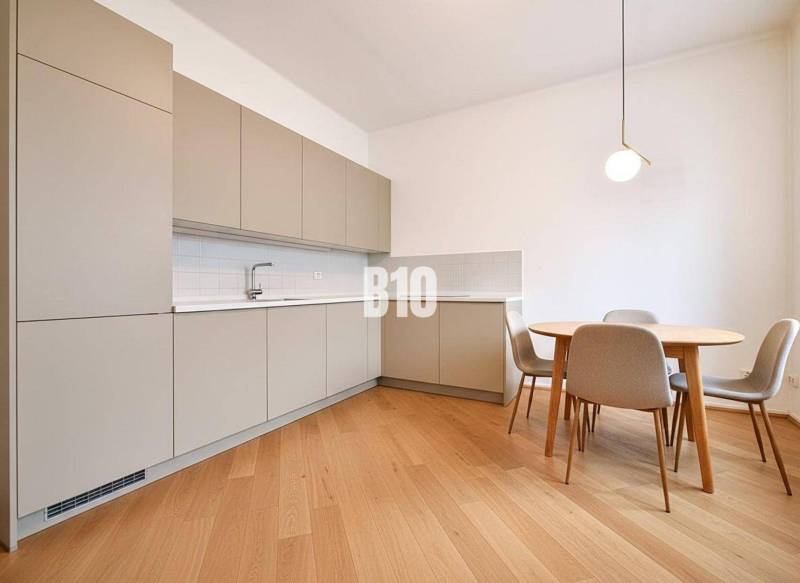 A kitchen in a family house with a wooden decor floor and a dining table with chairs.