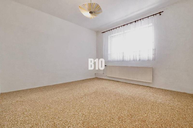 Spacious room with carpet and curtains in a family house.