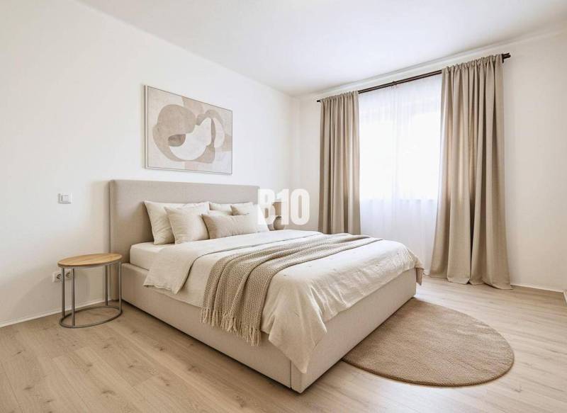 A bright bedroom with neutrally toned textiles and a wood-patterned floor in a family house.
