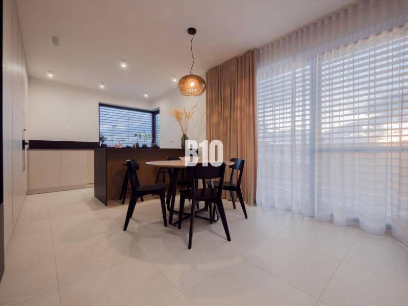 Dining nook with a window, curtains, and chairs in a family house with soft lighting.