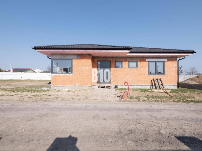 A family house in Veľký Lapáš with raw brick walls and a sloped roof.