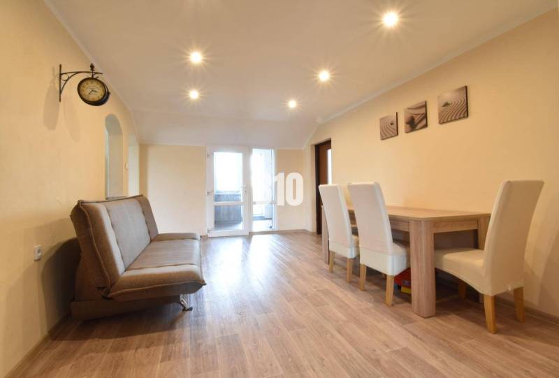 Living room in a family house with a sofa and a dining table.