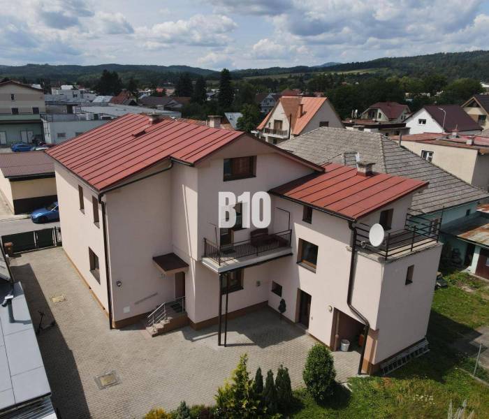 A family house in Bytča with a gable roof, a yard, and adjacent buildings.