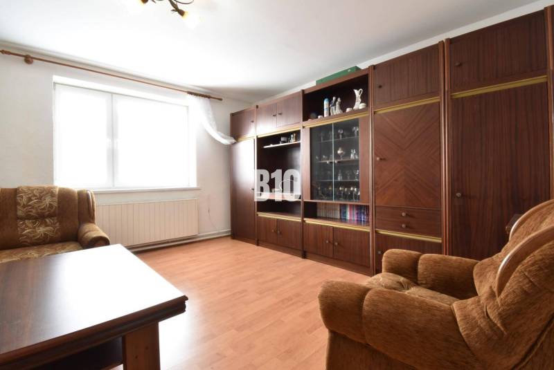 Living room in a family house with a seating set and a wooden wall unit.