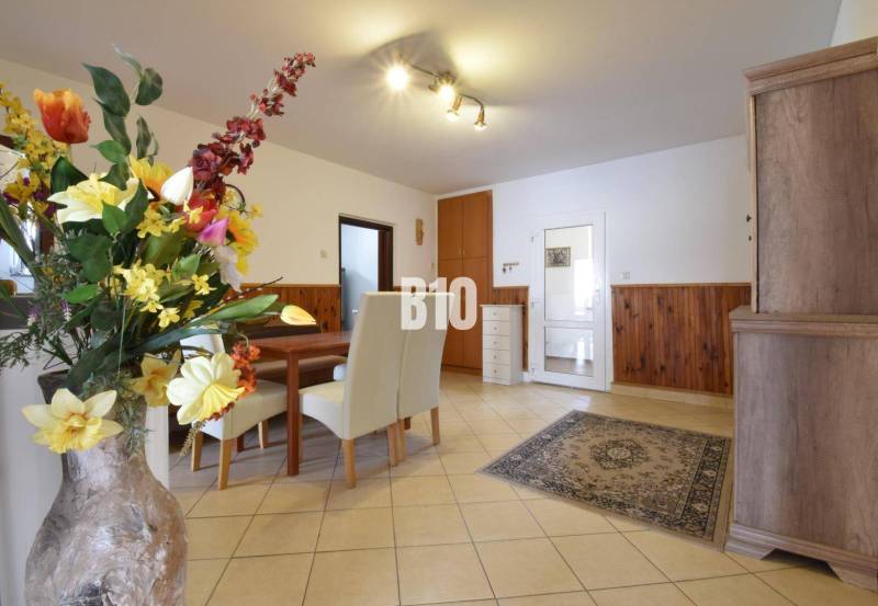 Dining room in a family house with floral decorations and wooden furniture.
