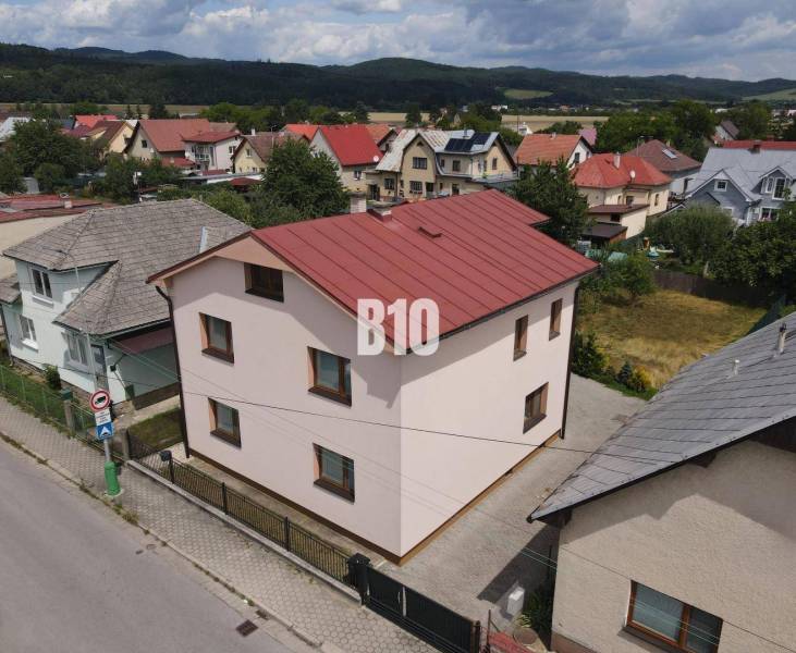 A family house in Bytča with a red roof, surrounded by other houses and nature.