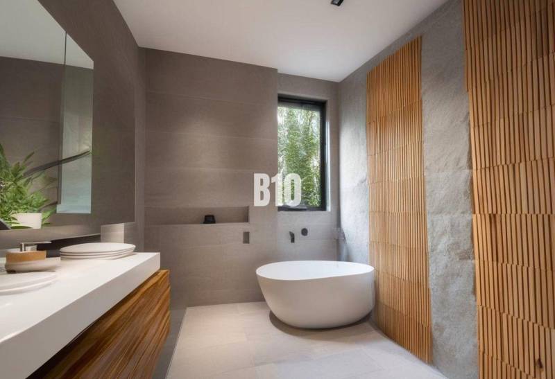 A bathroom in a cabin with a freestanding bathtub, wooden details, and a large window.