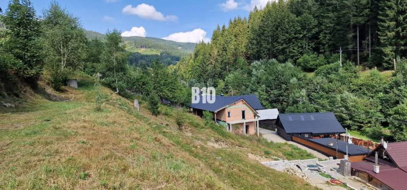 A family house situated in a valley with forests and hills. Charming natural scenery.