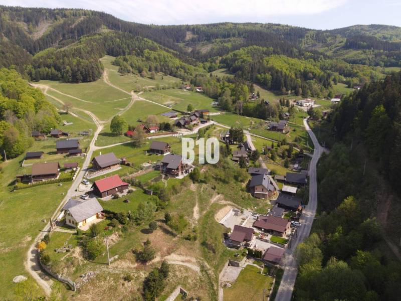 A view of family houses in Horný Marikovo, surrounded by forest landscape and meadows.
