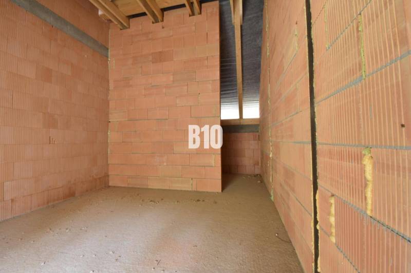 Unplastered bricks and an unfinished ceiling in a family house.