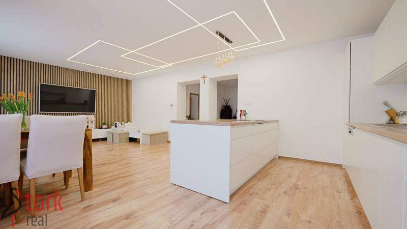 Kitchen and living room with wood-patterned flooring in a family house.