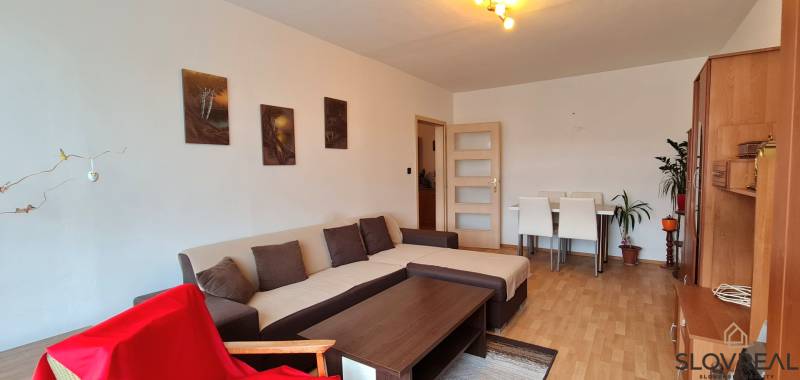 Living room with a corner sofa, floor with wood decor, and wooden furniture.