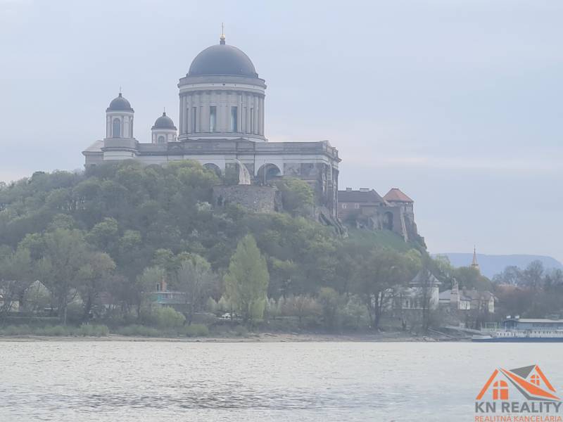 Basilica on a hill by the river in the town of Štúrovo, surrounded by greenery.