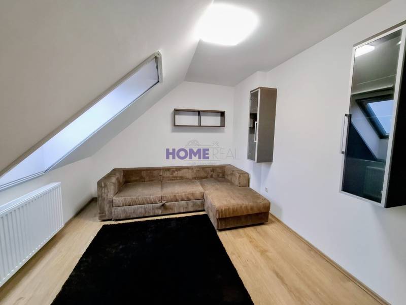 Living room with wood-patterned flooring in a three-room apartment.