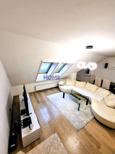 Living room in a three-room apartment with a wooden decor floor and a comfortable couch.