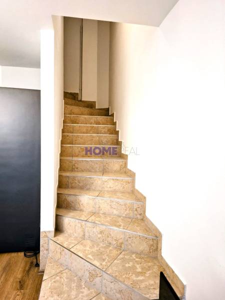 A staircase in a 3-room apartment with tiles and a transition to a floor with a wood decor.