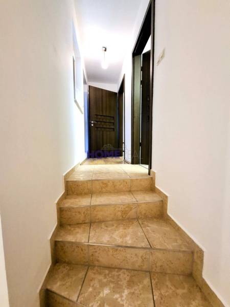 Hallway of a 3-room apartment with ceramic stairs and wooden doors.